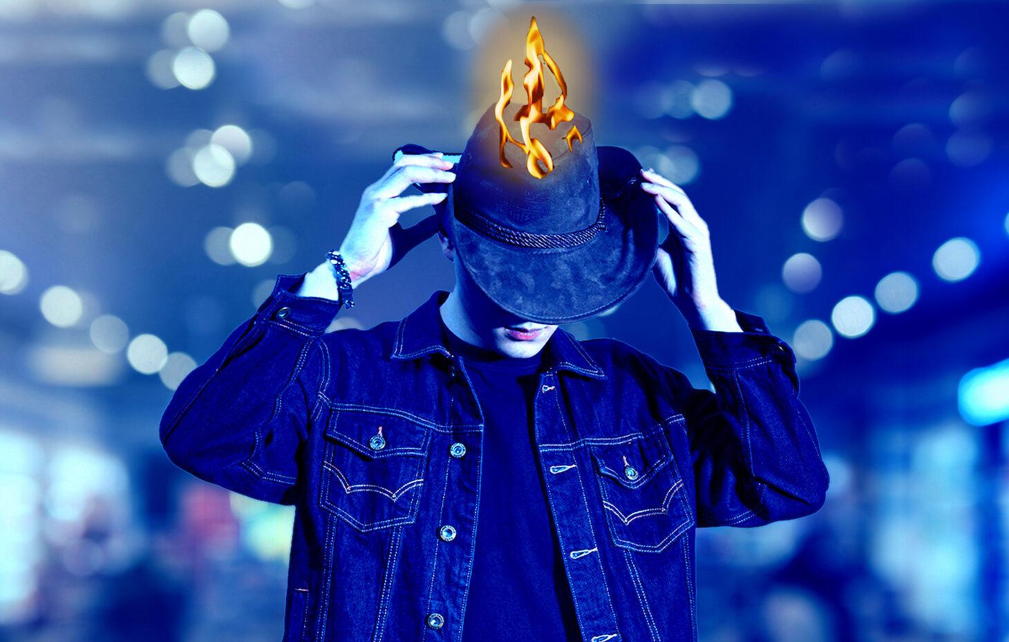 A man with a burning hat on his head.